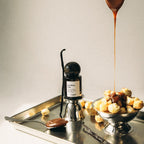 God Bless Cola Extrait de Parfum in einer dunklen Glasflasche mit Kugelverschluss vor hellem Hintergrund, Parfüm