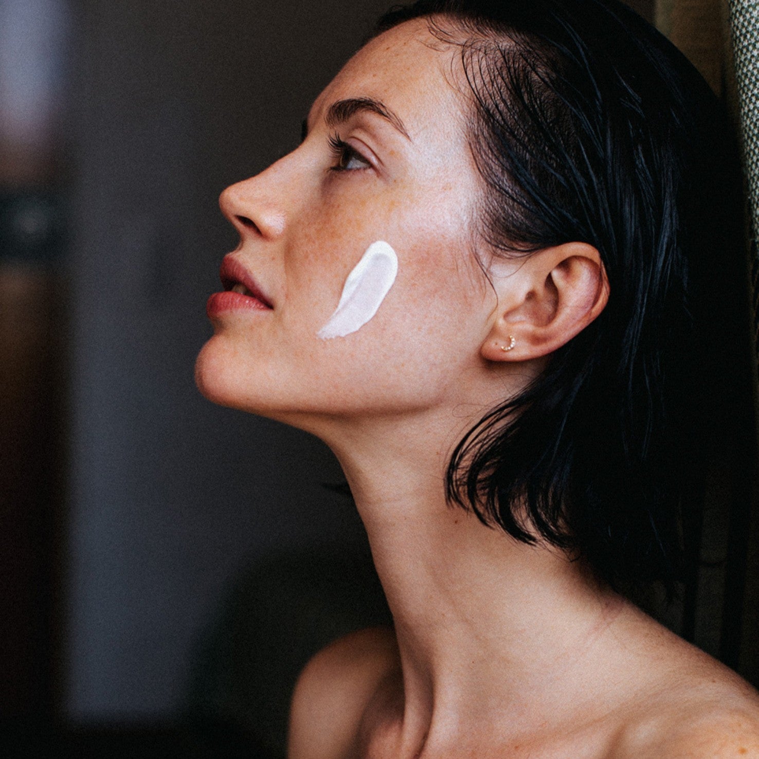Woman applying Le Masque Riche Réconfortant to her cheek, skin care