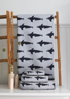 Orca Organic Cotton Beach Towel – grey with black orcas, on wooden ladder, white background – beach towel