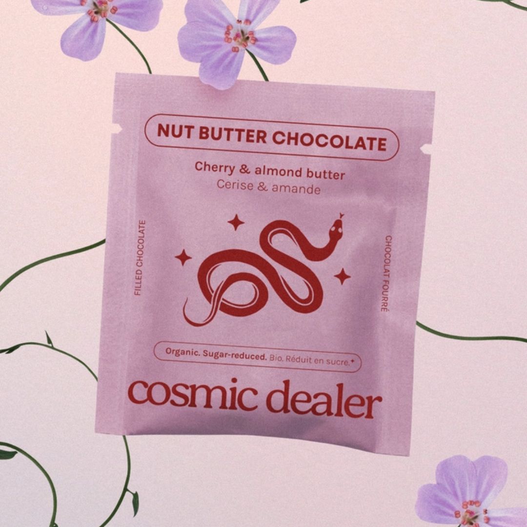 Cosmic Dealer Nut Butter Chocolate – purple pouch with cherry almond butter, pink floral background – snack