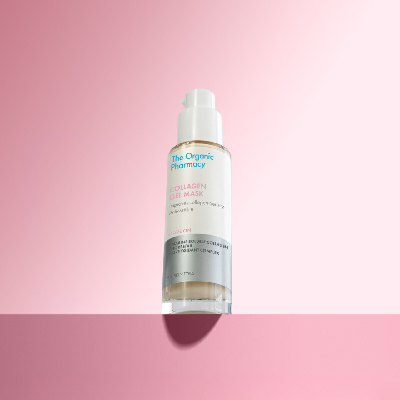 The Organic Pharmacy Collagen Gel Mask in einer Flasche mit Pumpe vor rosa Hintergrund, Hautpflege