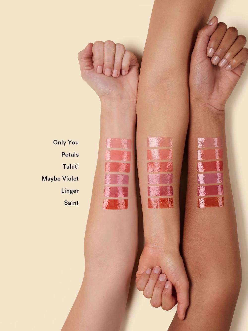 Balmy Gloss Tinted Lip Oil Farbfelder in verschiedenen Nuancen auf Armen, beiger Hintergrund, Lippenpflege