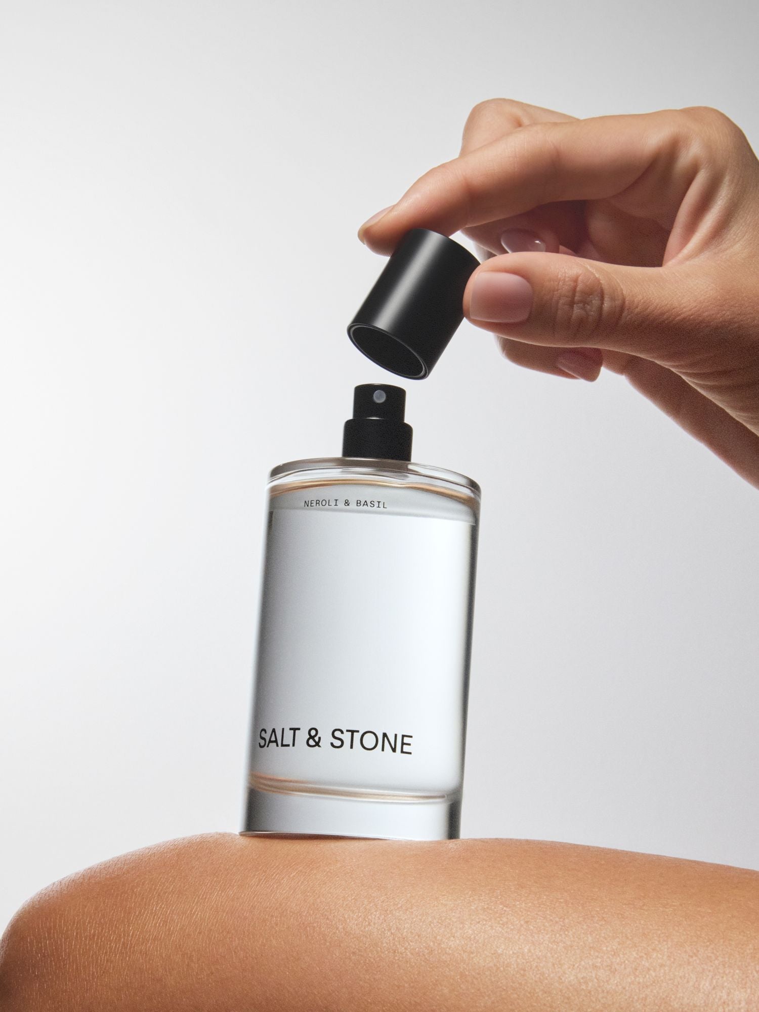 Salt & Stone Neroli & Basil Body Mist – klares Sprayfläschchen mit schwarzem Zerstäuber, weißem Etikett, weißem Hintergrund – Körperpflege