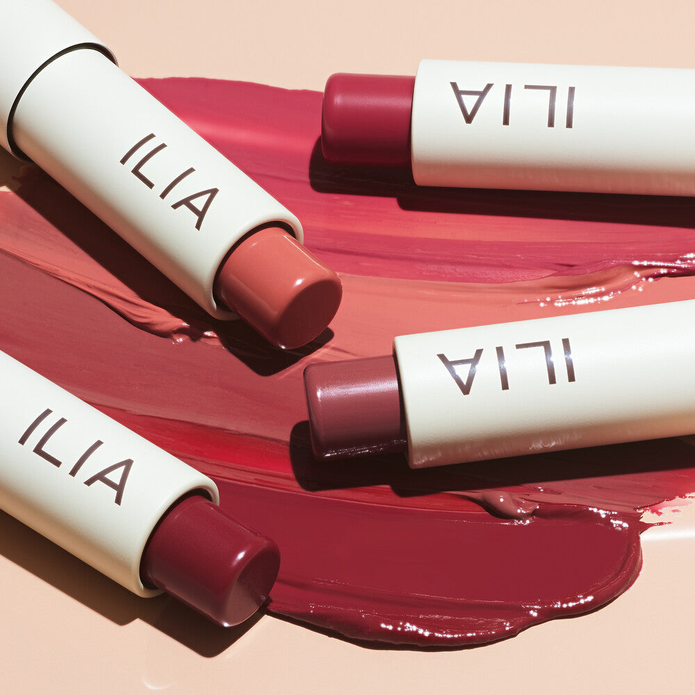 ILIA Balmy Tint Hydrating Lip Balm – cream tube with colored sticks, pink background – lip care