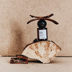 Gueule de Bois Extrait de Parfum in a dark glass bottle with a ball cap on wood, 50ml, niche fragrance