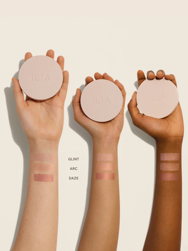 Drei ILIA Lightshift Cream Highlighter in beigefarbenem Tiegeln mit Deckel auf hellem Hintergrund, Make-up Highlighter