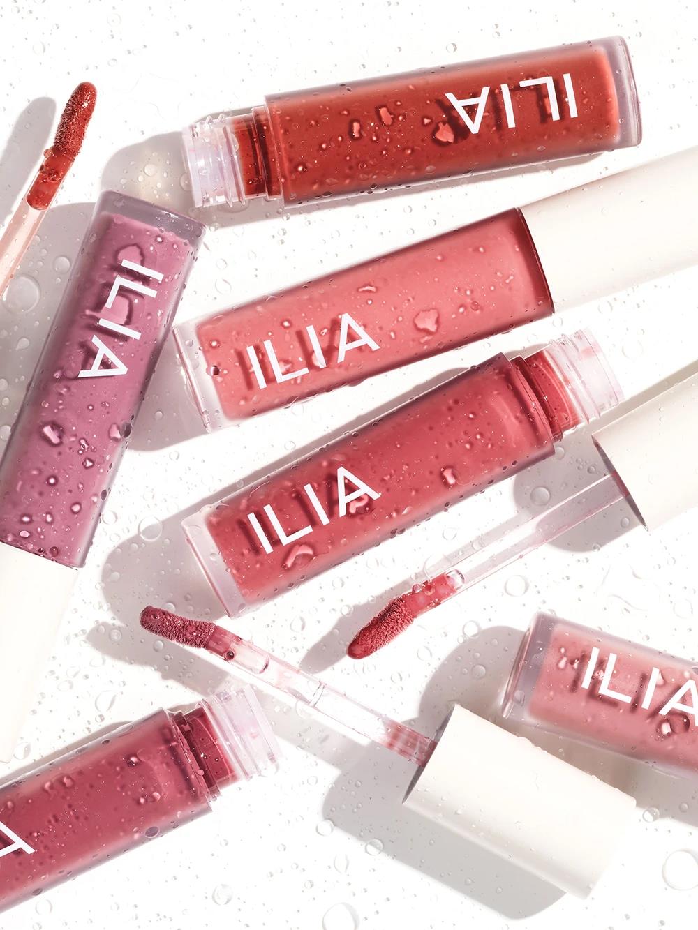 ILIA Balmy Gloss Tinted Lip Oil in verschiedenen roten Farbtönen in Tuben auf weißem Hintergrund, Lippenpflege