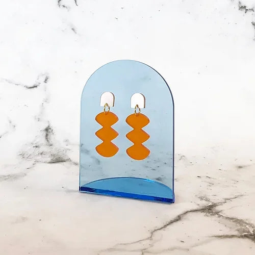 Spectral Orange Earrings – orange geometric shapes on blue acrylic holder, marble background – jewelry