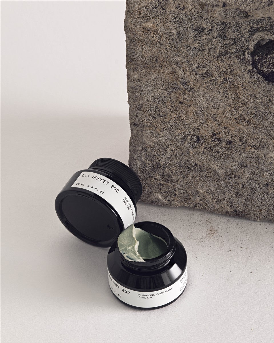 L:A BRUKET No. 302 Reinigende Gesichtsmaske – schwarzer Tiegel 50ml, weißes Etikett, grauer Hintergrund – Hautpflege