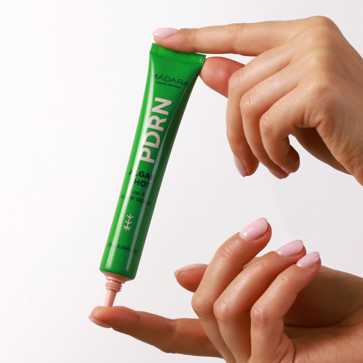 Mádara PDRN Algae Shot 7-in-1 Serum in grüner Tube, Produkt in Anwendung mit Texturprobe auf dem Finger.