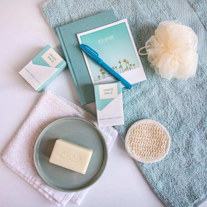 KLAR Sea Salt Soap – cream-colored bar on gray dish, blue and white packaging, light blue background – skin care