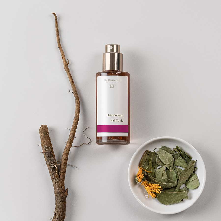 Dr. Hauschka Hair Tonic – brown glass bottle with spray nozzle, white label and purple stripe, white background – hair care