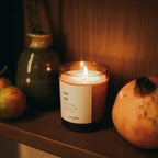 Eat Me scented candle in a brown glass jar on a dark wooden background, cozy home fragrance candle