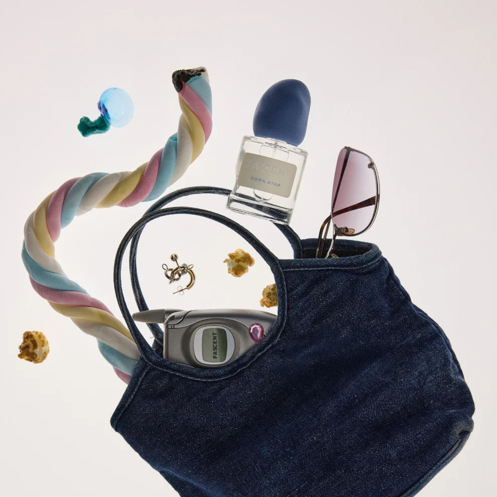 Fascent Corn Star Eau de Parfum – klares Glasfläschchen mit blauem Sprühkopf, in Jeans-Tasche, weißer Hintergrund – Parfüm