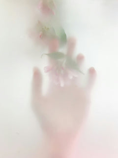 Aesthetic detail shot of body scrub gloves in soft pink tones for skin care.