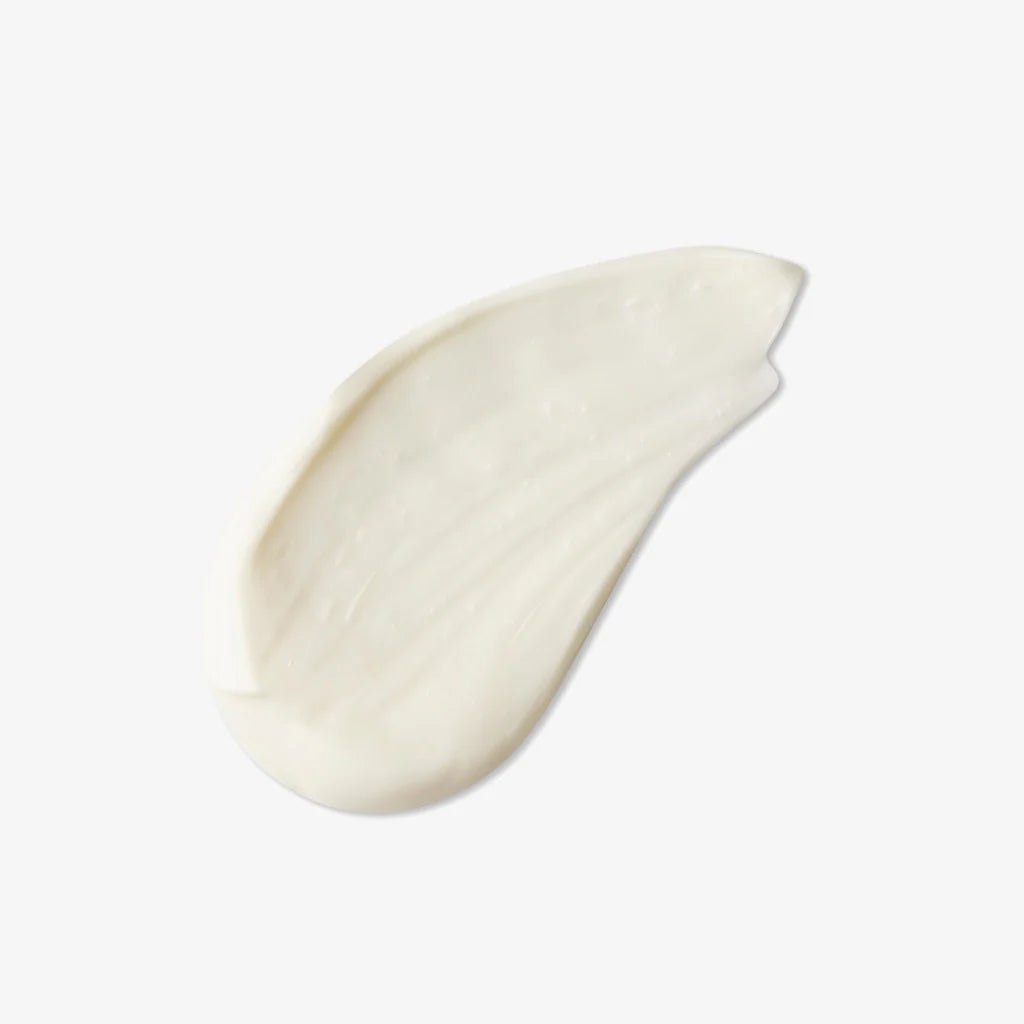 Swatch of Pure Tranquility Hand & Body Lotion as a white cream smear on a light background, skin care