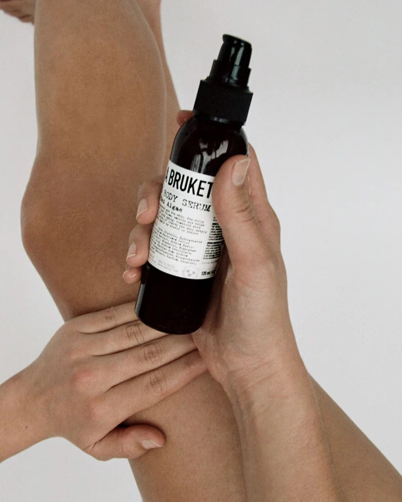 A BRUKET No. 290 Firming Body Serum – dark glass bottle 120ml, black spray pump, white background – skin care