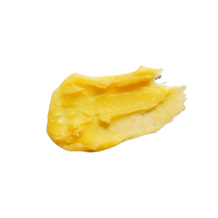 Texture of Carrot Butter Cleanser, yellow butter cream on white background, skin care