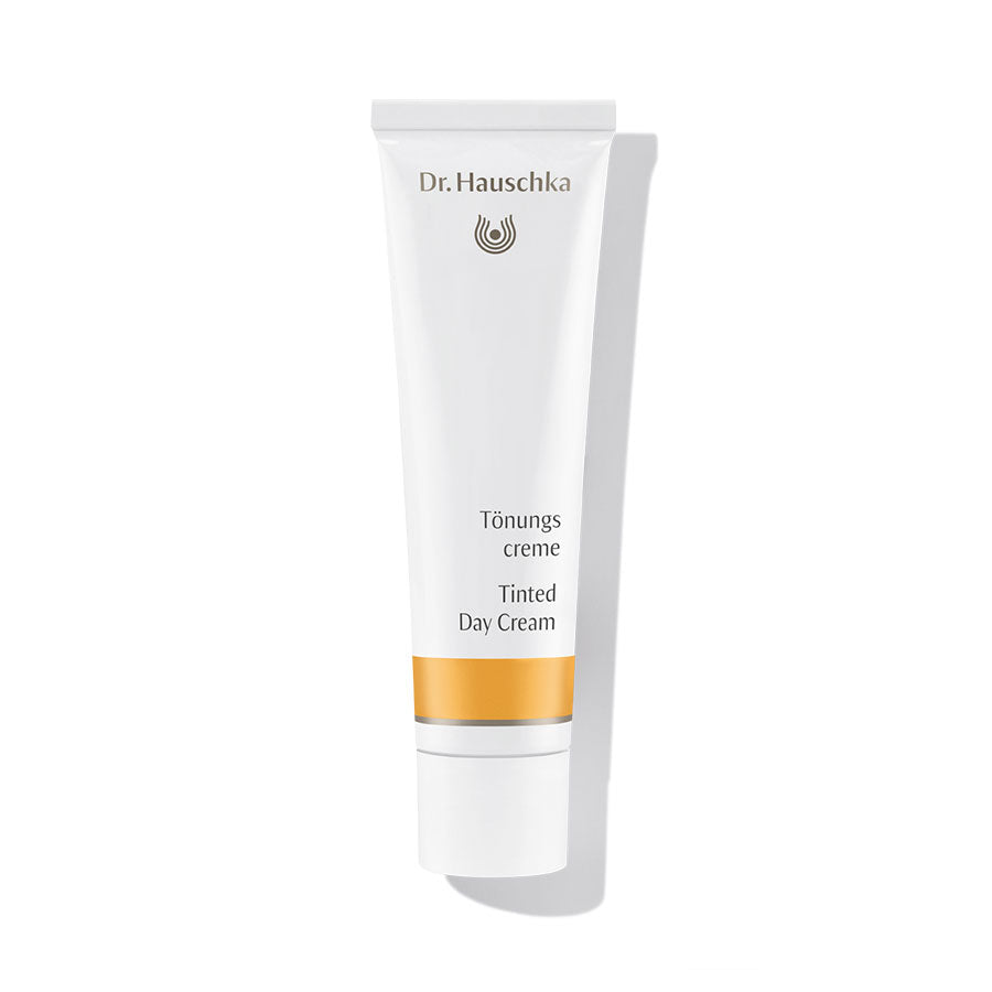 Dr. Hauschka Tinted Day Cream – white tube with orange stripe, white cap, white background – face care