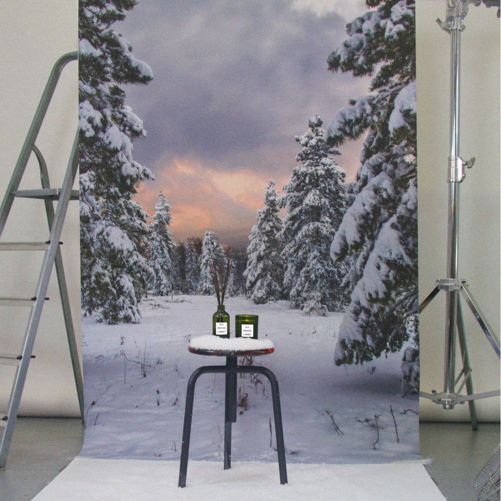 No. 332 Winter Pine – grüne Glasflasche mit Diffusor, weißem Etikett, auf schwarzem Hocker vor verschneitem Wald – Raumduft