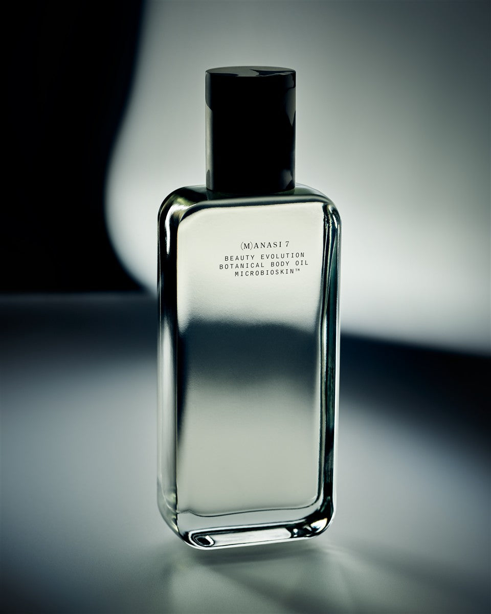 (M)ANASI 7 Botanical Body Oil – klares Glasfläschchen mit schwarzem Deckel, dunkler Hintergrund – Körperpflege
