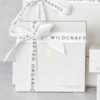 Wildcrafted Organics Luxus-Muslin-Reinigungstücher – weißes Geschenkbox-Set mit Schleife, grauer Hintergrund – Hautpflege