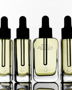 Botanical Face Oil Armonia – klares Glasfläschchen mit schwarzer Pipettenkappe, cremefarbener Inhalt, weißer Hintergrund – Hautpflege