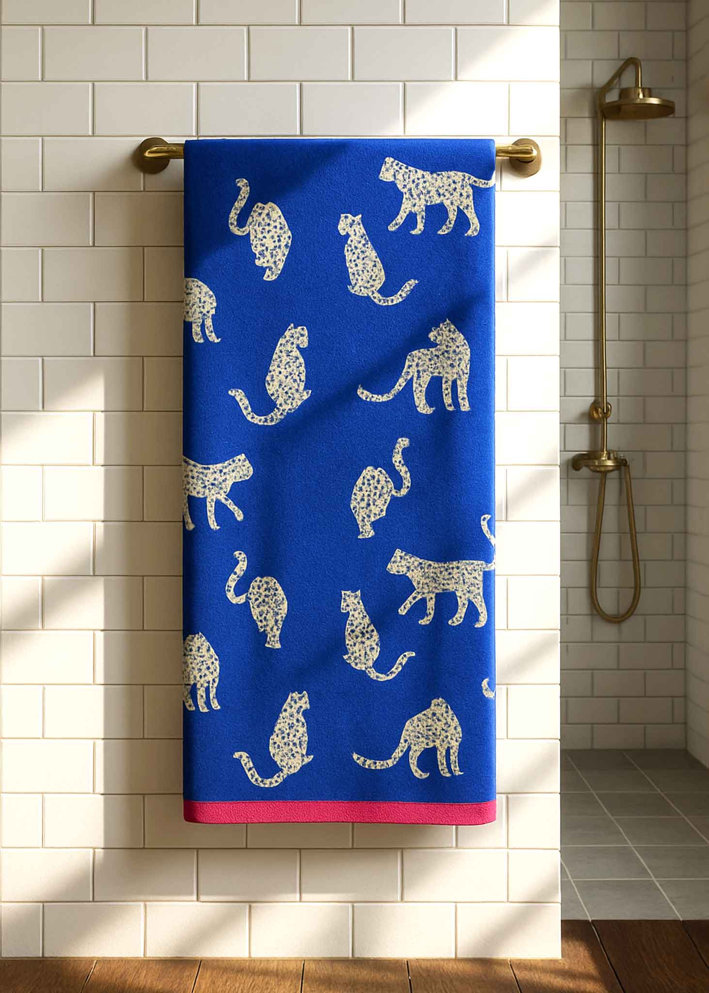 Snow Leopard Organic Cotton Bath Towel with leopard print, blue with pink hem, hanging on rack – bath towel