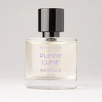 Pleine Lune Eau de Parfum – clear glass bottle with black cap, purple text, white background – perfume