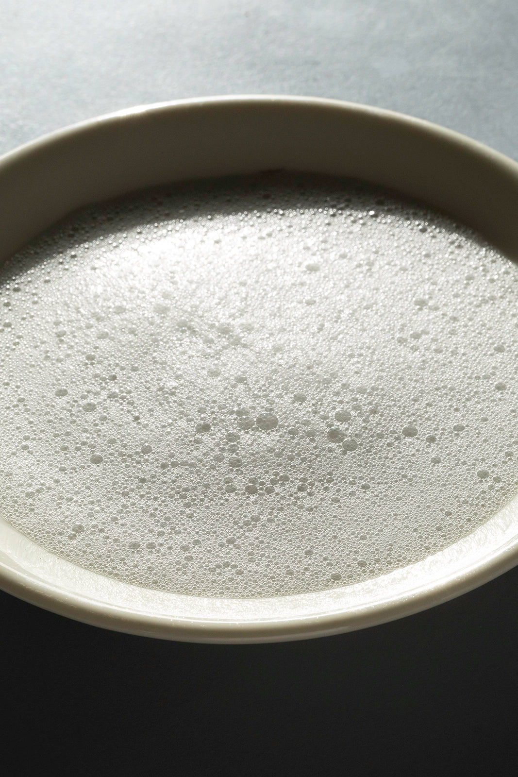 Smoothiebody Bath Red Mandarin – creamy foam in white bowl, gray background – body care