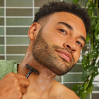 Perfect Glide Safety Razor Black – man shaving with black safety razor, green tiles and plant background – shaving
