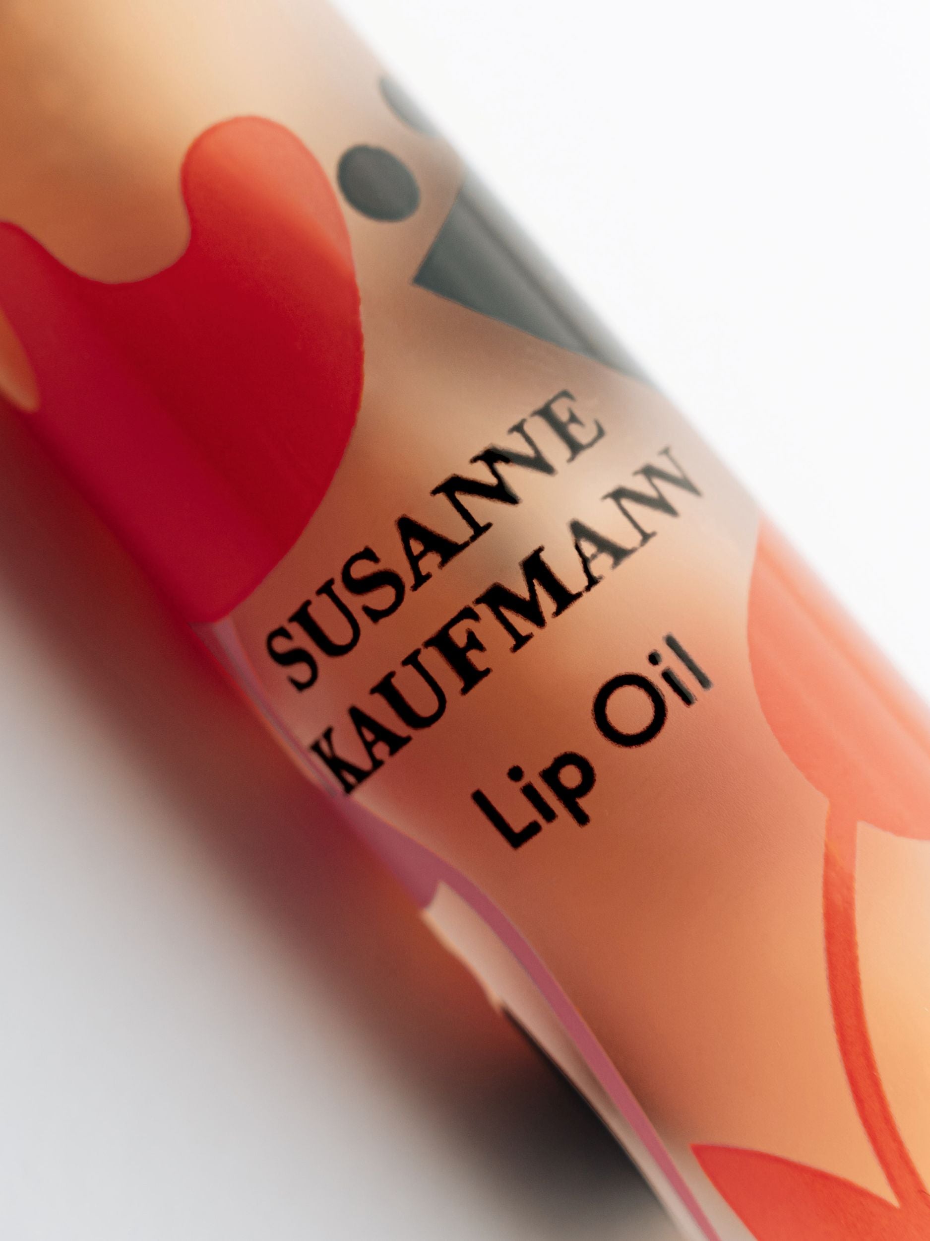 Susanne Kaufman Lip Oil Roll On mit roten Mustern auf weißem Hintergrund, Lippenpflege