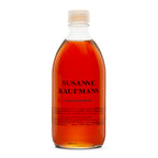 Susanne Kaufmann Hayflower Bath Oil in einer durchsichtigen Glasflasche mit weißem Schraubverschluss, Körperpflege