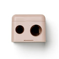 Precision Dual Sharpener, rose-colored dual pencil sharpener on white background, makeup accessory.