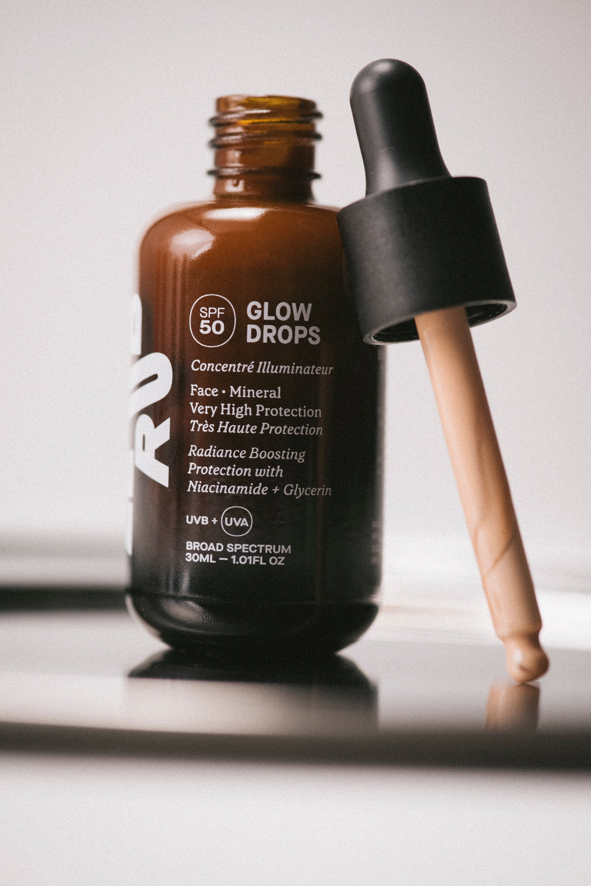 Glow Drops SPF 50 braune Glasflasche mit Pipette, im Bad