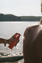" Personen am Strand mit orangefarbene Sprühflasche 