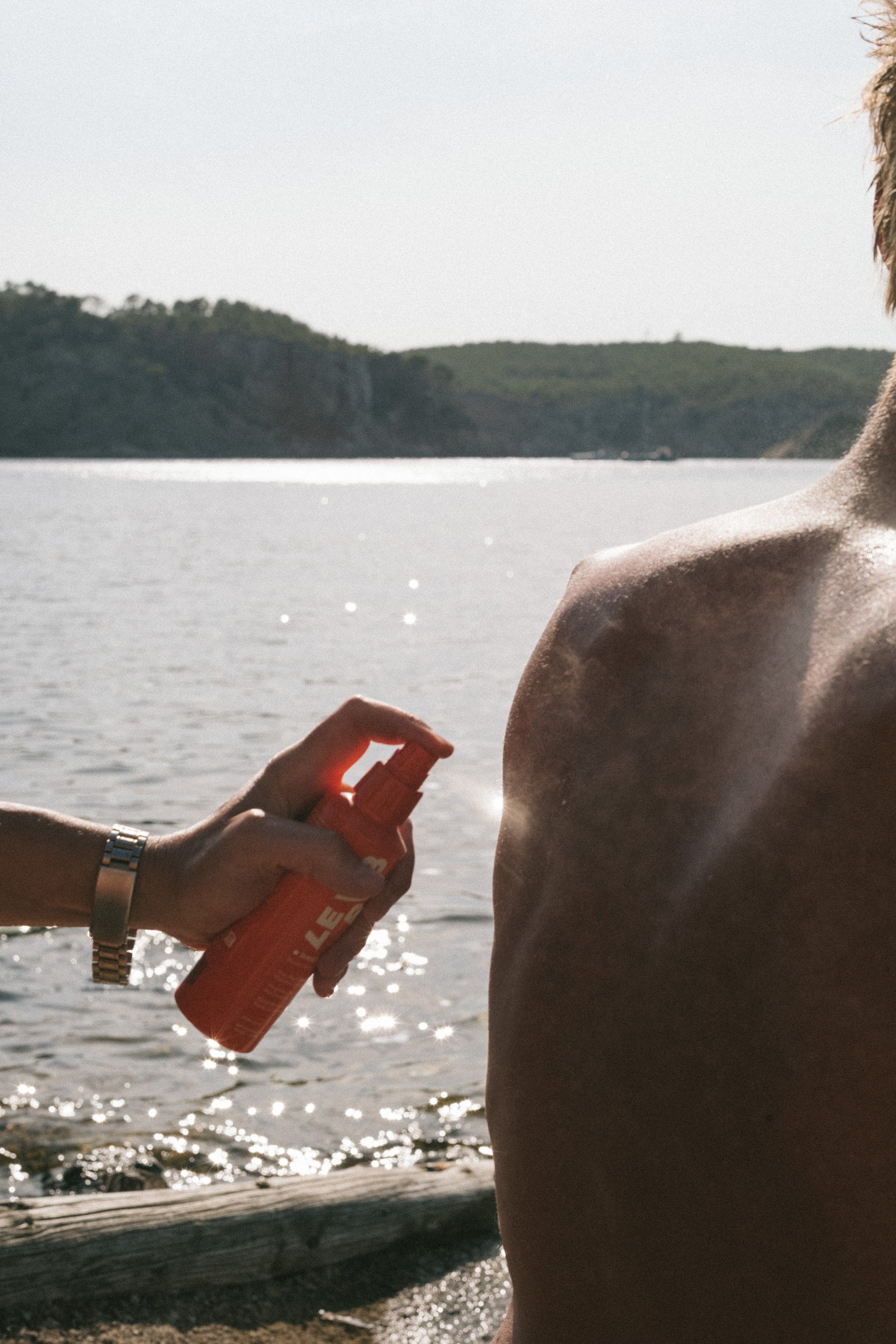 " Personen am Strand mit orangefarbene Sprühflasche 