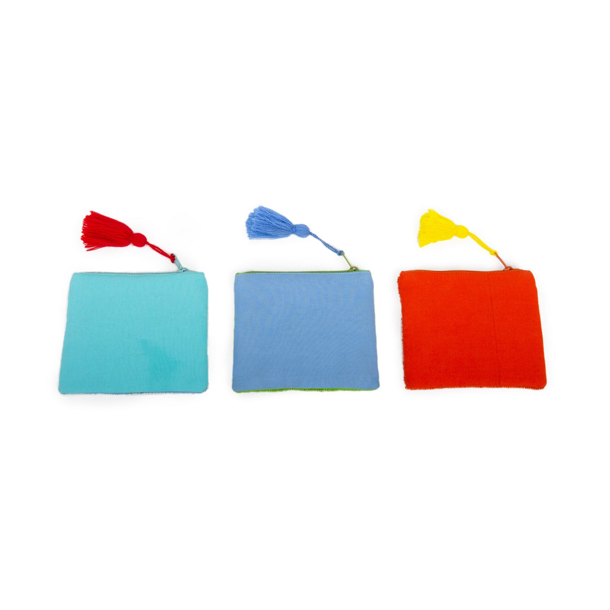 Drei quadratische kleine Taschen in Türkis, Blau und Rot, jeweils mit einer farbigen Quaste.
