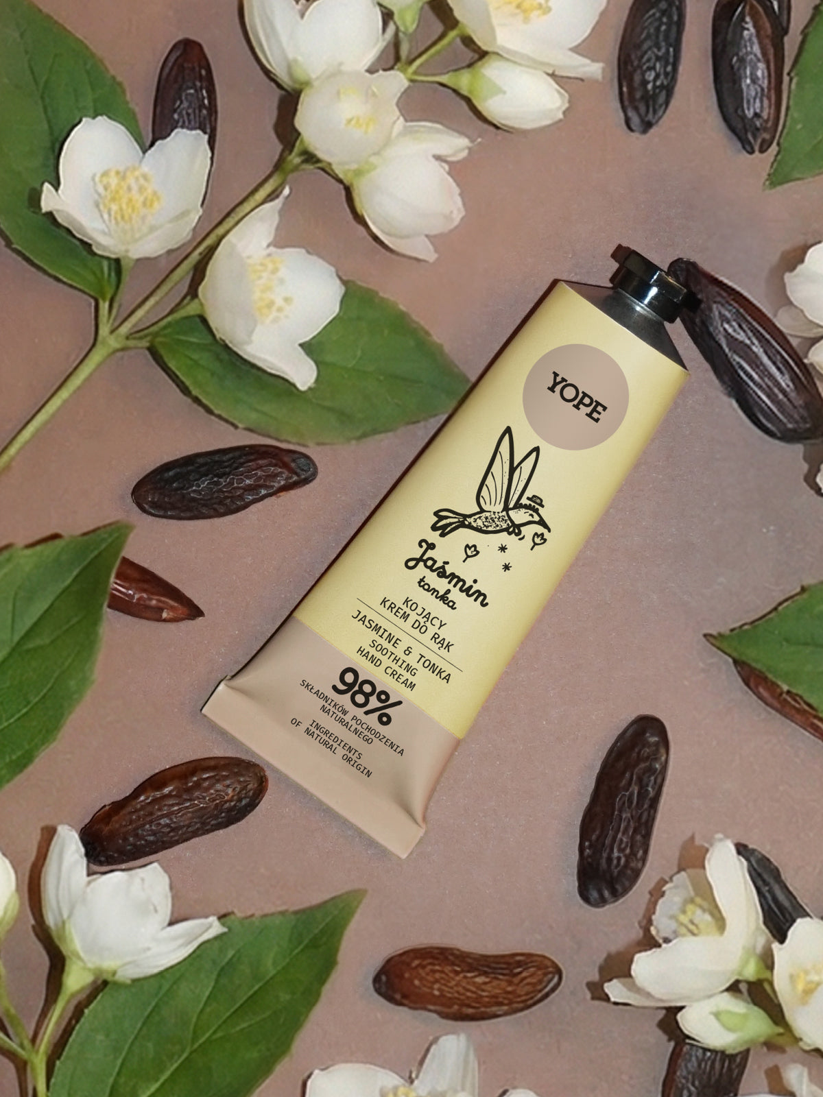 Yope Handcreme mit Jasmin und Tonka, umgeben von weißen Jasminblüten und Tonkabohnen.