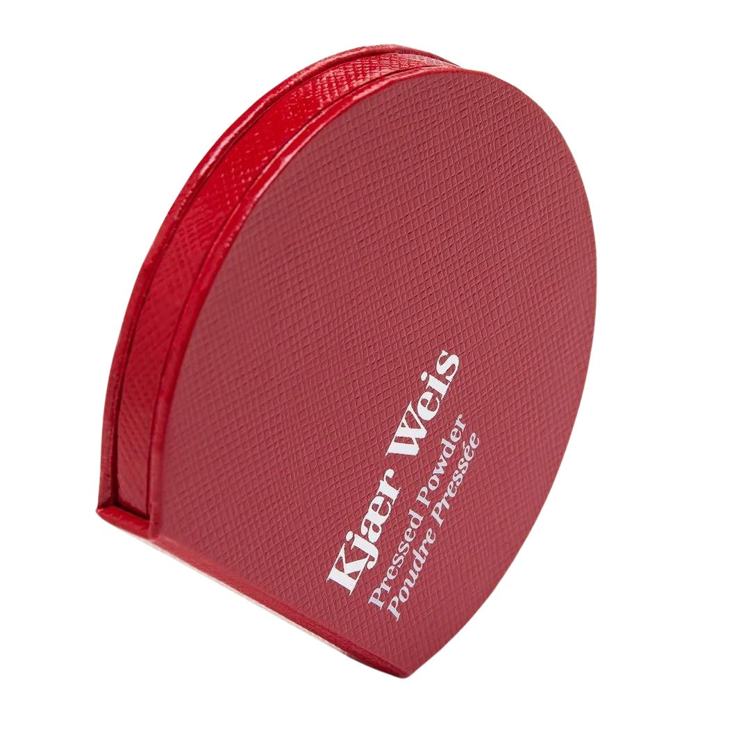 Kjaer Weis Pressed Powder – rote Puderdose mit strukturierter Oberfläche, weißem Schriftzug, weißem Hintergrund – Make-up