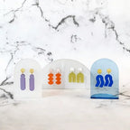 Spectral Orange – colorful earrings on acrylic display, marble background – accessories
