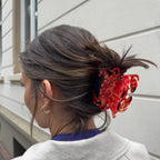 Red marbled hair claw clip in a woman's hair against a light background, hair styling