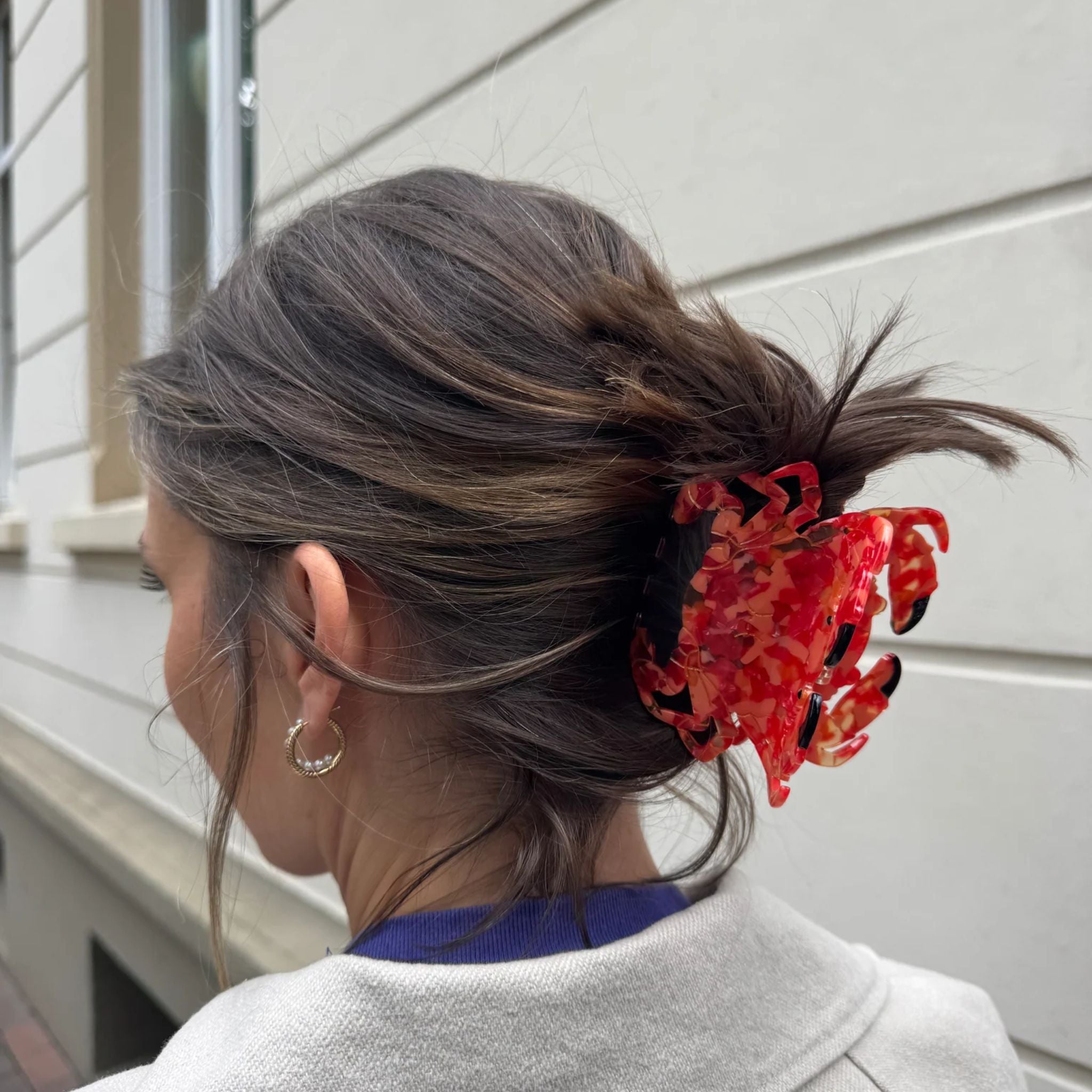 Red marbled hair claw clip in a woman's hair against a light background, hair styling