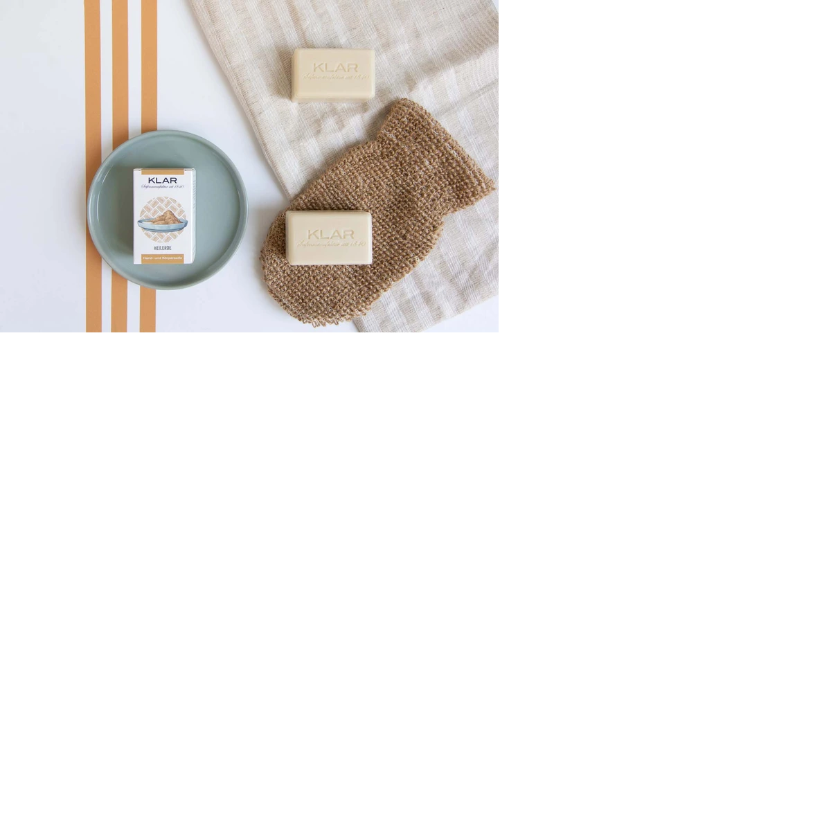 KLAR Healing Clay Soap – cream-colored soap bars, packaging on green plate, beige cloth – skin care
