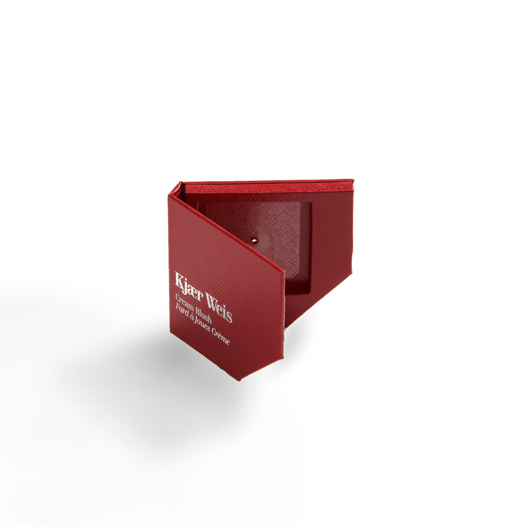 Kjaer Weis Cream Blush – rote Texturbox, weißer Schriftzug, weißer Hintergrund – Gesichtspflege