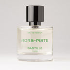 Bastille Hors-Piste Eau de Parfum – clear glass bottle with black cap, green text, white background – perfume