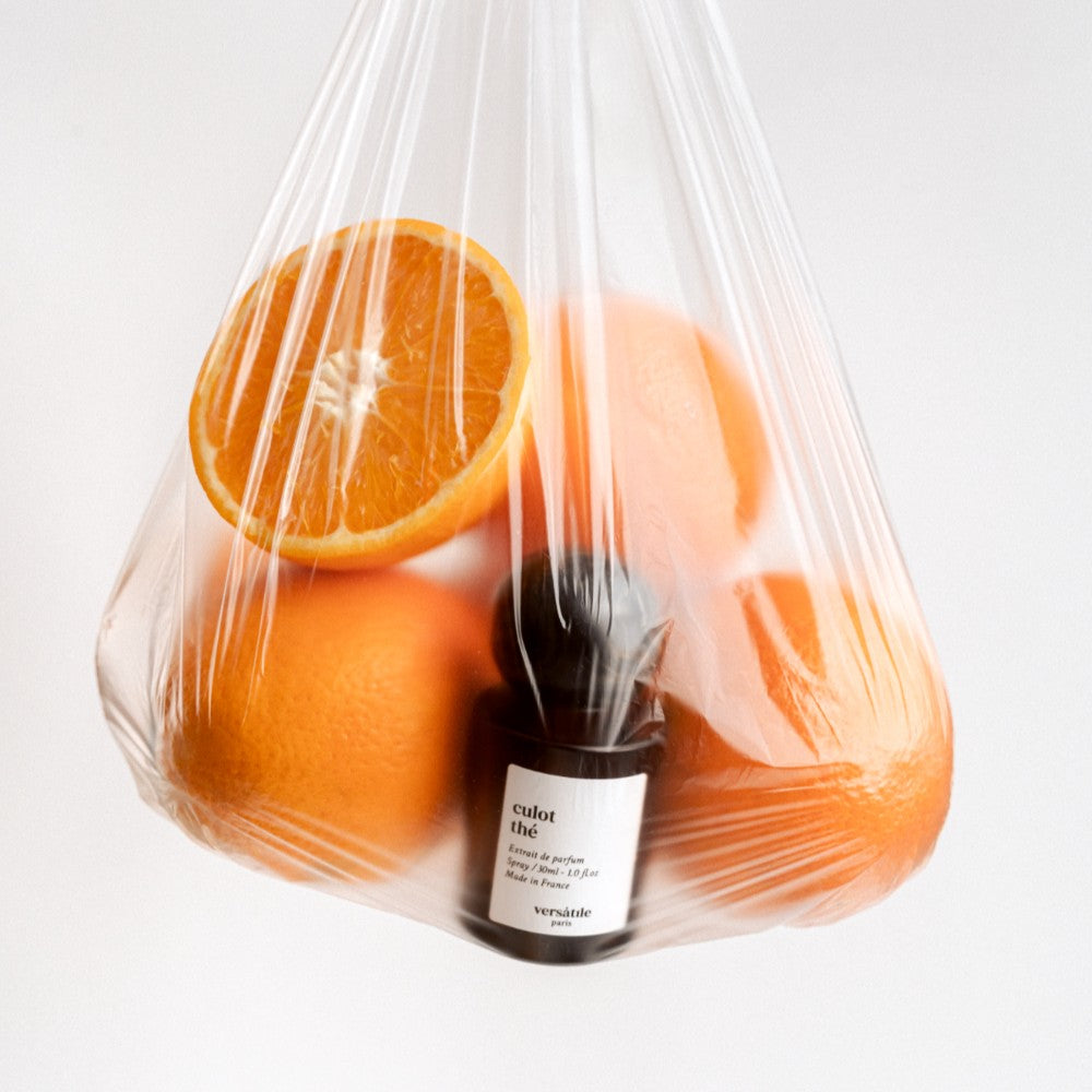Culot Thé Extrait de Parfum in einer dunklen Glasflasche mit Sprühkopf in einer Plastiktüte mit Orangen, Parfüm