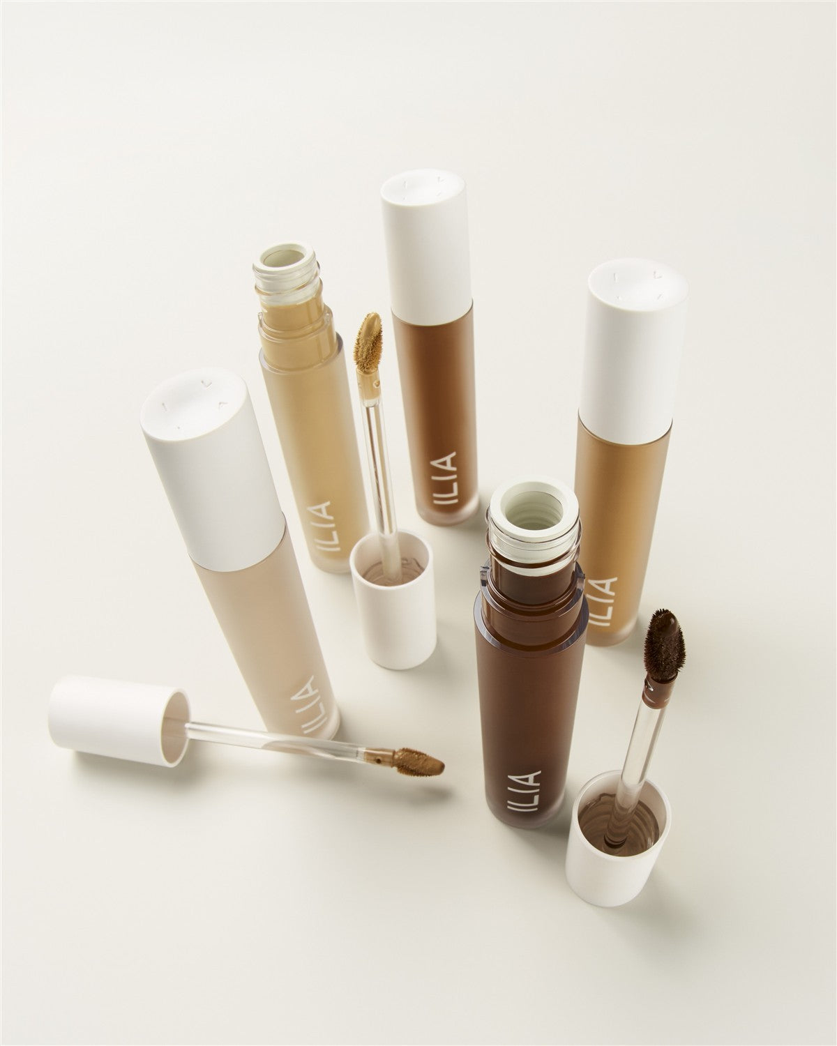 ILIA Skin Blur Serum Concealer – durchsichtige Tube mit weißem Deckel, verschiedene Nuancen auf hellem Hintergrund – Hautpflege