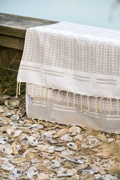 Biarritz Grey grey and white textile product on a bed of oyster shells, beach accessory