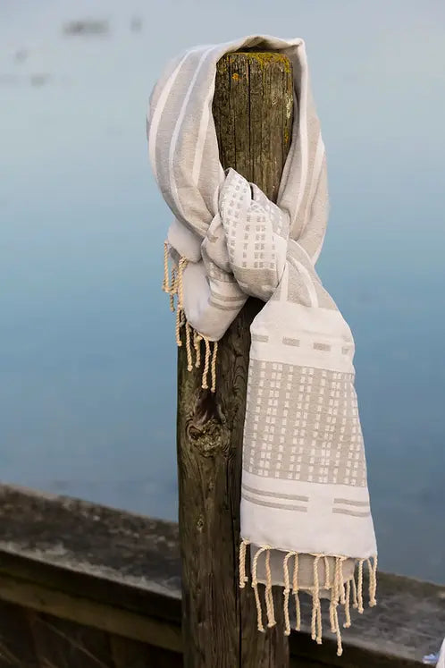 Biarritz Grey Schal in Grau und Weiß an einem Holzpfahl vor blauem Hintergrund, Mode-Accessoire